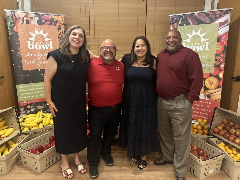 Four of the Daily Bowl team standing with crates of rescued produce