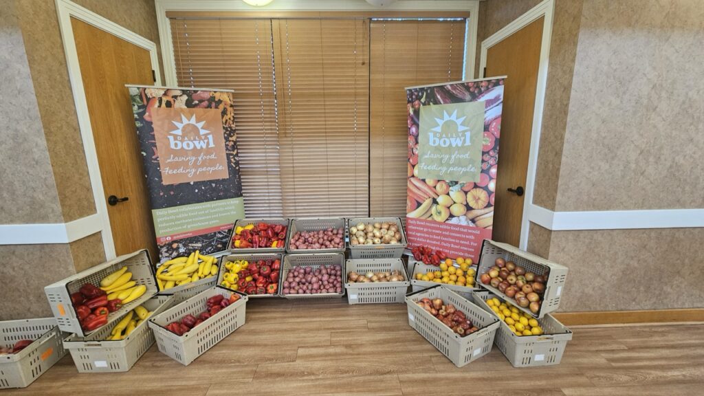 Crates of rescued produce lined up between the Daily Bowl banners